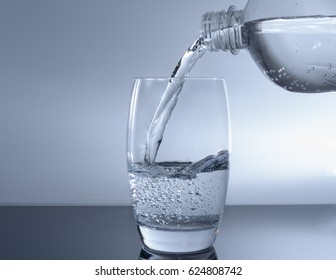 Filling Water In Glass From Waterbottle To Drink