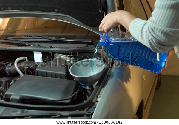 Filling the\
windshield washer fluid on a Car\
