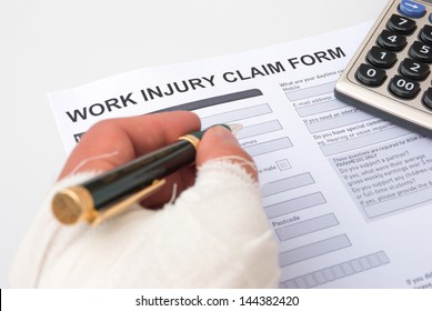 filling up a work injury claim form with a wrapped hand, medical and insurance concept