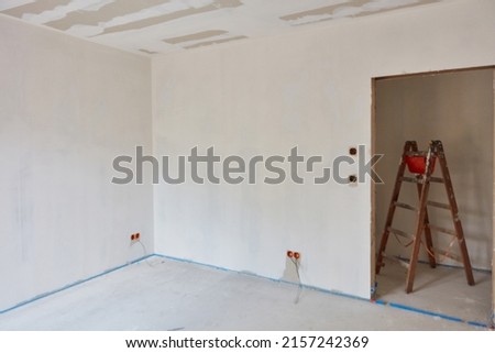 Filling work and interior plastering on walls and ceilings are done in an empty room when building a house