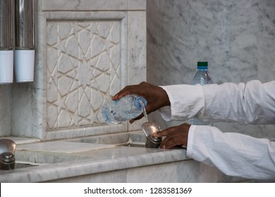 Filling Zamzam Water Into The Bottle. Zamzam Well In Masjid-Haram.  