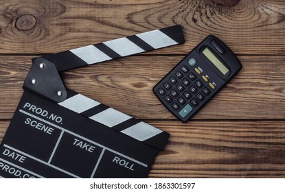 Film Clapper Board With Calculator On Wooden Background. Cinema Industry, Entertainment. Top View