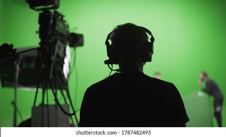 Film crew in green studio shooting video. Chroma - technology of combining two or more images or frames in single composition. Cameraman,director,crew. Filmmaking industry. - Shutterstock ID 1787482493