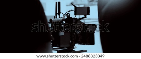 Film director and crew making commercial content advertising in studio. Filmmaker crew team with professional cinema equipment and video camera on the set. Technique of modern filming and advertising.