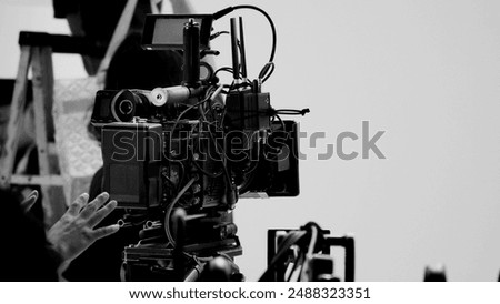 Film director and crew making commercial content advertising in studio. Filmmaker crew team with professional cinema equipment and video camera on the set. Technique of modern filming and advertising.