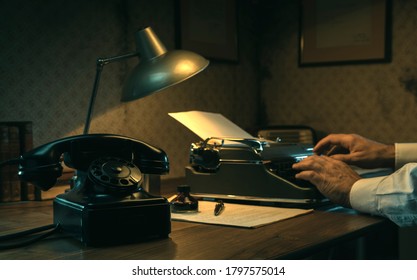 Film noir journalist working at office desk in the office, he is typing with a vintage typewriter