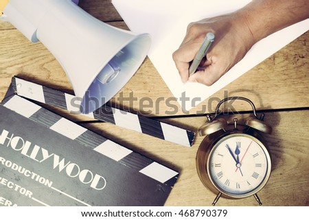 Film production process. Planning to make movie. Clapperboard, megaphone, piggy bank, mobile phone and alarm clock on wooden table background