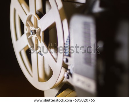 film projector on a black background with dramatic lighting and selective focus