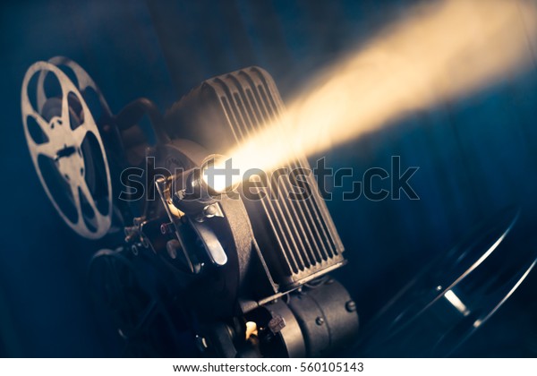 film projector on a wooden background\
with dramatic lighting and selective\
focus