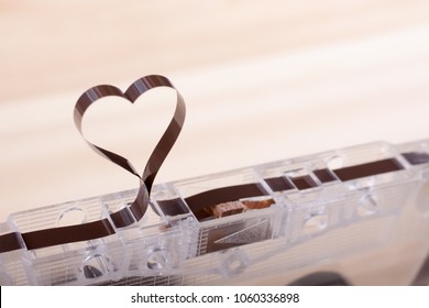 Film In A Shape Of Heart From Compact Cassette. Love For Music And Songs. Wooden Background