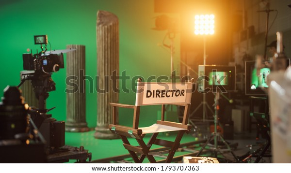 Film Studio Set with Focus on Empty Director\'s\
Chair. On the Studio Film Set with High End Equipment Professional\
Crew Shooting High Budget\
Movie
