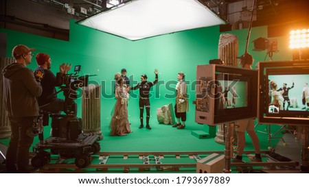 Film Studio Set: Shooting Green Screen Scene with Two Talented Actors Wearing Renaissance Clothes Talking, Director Finishes Scene, Celebrates Success, Embraces Actors. Period Drama Movie Backstage