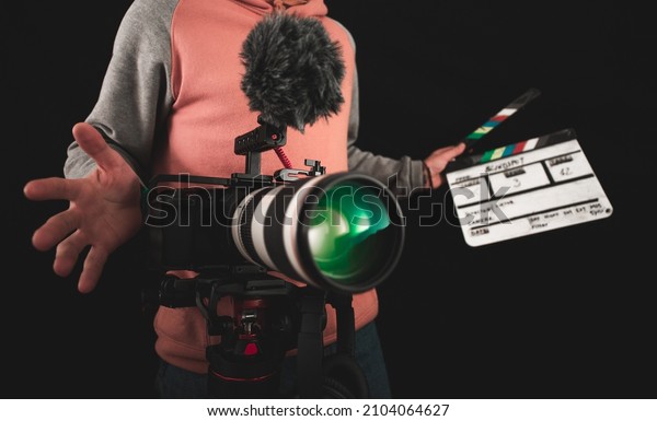 Filmmaker or\
cinematographer using professional camera gear to make\
documentaries and movies. Young cameraman, audiovisual, story\
telling and directing movies\
concepts.