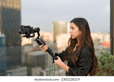 Filmmaker girl recording on the terrace of a skyscraper  - Powered by Shutterstock