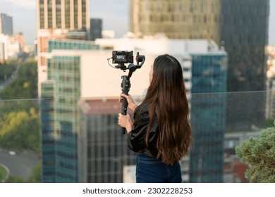 Filmmaker girl recording on the terrace of a skyscraper  - Powered by Shutterstock