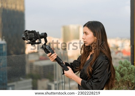Filmmaker girl recording on the terrace of a skyscraper 