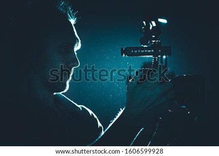Filmmaker with Modern DSLR Video Camera Taking Shot in a Dark. Making Documentary Film. Professional Videography Equipment.