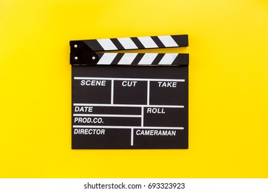 Filmmaker profession. Clapperboard on yellow background top view copyspace - Shutterstock ID 693323923