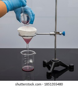 Filter paper in laboratory. Scientists are chemical filtration by filtering through filter paper in a glass funnel, Close up. Pharmacist filtering substance in the lab.