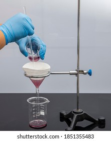 Filter paper in laboratory. Scientists are chemical filtration by filtering through filter paper in a glass funnel, Close up. Pharmacist filtering substance in the lab.