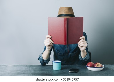 Filtered Photo Of A Young Hipster Man Reading A Book And Relaxing