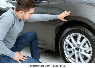 Final Check. Horizontal Portrait Of A Man Checking Tires On His New Car