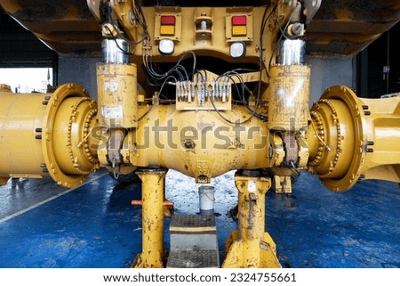 final drive and axle of a giant mining dump truck being serviced at workshop