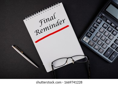 Final Reminder notepad writing concept on dark background with pen and calculator.