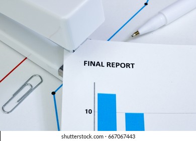 Final Report Light
Closeup Of A White Stapler Being Used To Bind Pages Of A Final Report Together Which Is On A Desk Filled With Printed Graphs.