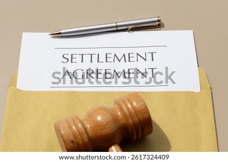 Final Resolution: Settlement Agreement Document with Gavel on Wooden Desk