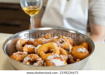 Final result of homemade tradition donuts served with a cup of wine.