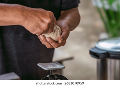 Final step of making a handmade dumpling. A chef's hands expertly press and seal the pleated dough to complete the preparation.