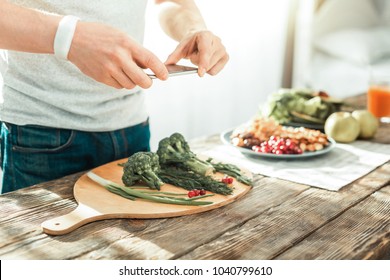 Final variant. Skilful creative smart man standing near the table making photo and cooking. - Shutterstock ID 1040799610