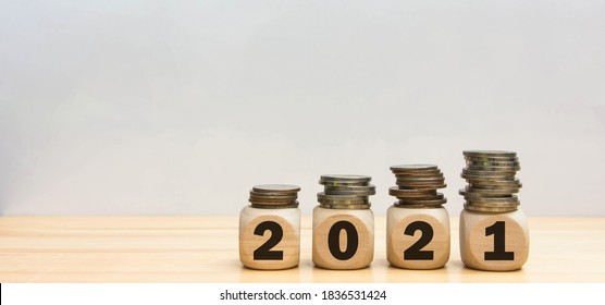 Finance coins stack 2021 wood cube on white background.  
New year 2021 financial and saving money concept.