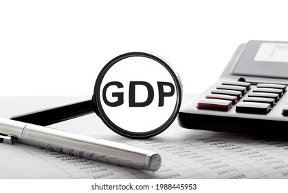 Finance And Economics Concept. Magnifier On White Background With Text GDP, With Pen,calculator And Chart.