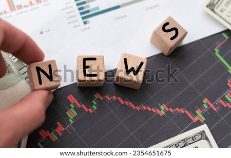Finance and economy concept. On the table with charts of quotes are a pencil and pieces of paper with the inscription - LATEST NEWS