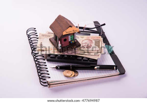 Finance\
and Housing Loan or purchase in India -  Concept showing 3D house\
model, indian currency notes and calculator\
etc