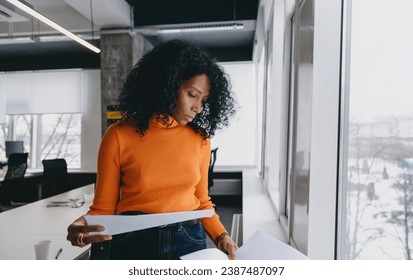 A finance manager analyzes fiscal documents, strategizing sustainable investment against a snowy backdrop in a luminous office space. - Powered by Shutterstock