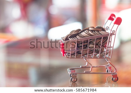 Finance and money concept mini shopping cart red blurry background