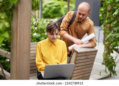 Finance And Real Estate Concept. Meeting Of Coworkers Talking About Job Outdoor At Summer. Team Of Young Economist Managers Or Real Estate Agents In Casual Clothes Outdoors. High Quality Image