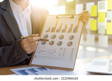 Finance Staff Holding Financial Graph Documents Presented To Executives And Attendees Via Videoconference, Meeting To Summarize The Operations Of All Departments. Videoconferencing Concept.