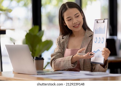 Finance Staff Holding Financial Graph Documents Presented To Executives And Attendees Via Videoconference, Meeting To Summarize The Operations Of All Departments. Videoconferencing Concept.