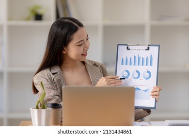 Finance Staff Holding Financial Graph Documents Presented To Executives And Attendees Via Videoconference, Meeting To Summarize The Operations Of All Departments. Videoconferencing Concept.