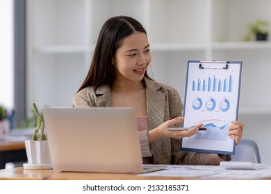 Finance Staff Holding Financial Graph Documents Presented To Executives And Attendees Via Videoconference, Meeting To Summarize The Operations Of All Departments. Videoconferencing Concept.