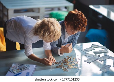 Finance. Two boys counting money and looking involved - Powered by Shutterstock