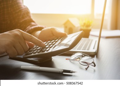 finance,accounting,Businessman analyzing investment charts with calculator laptop calculate technology in office,business, concept,selective focus,vintage color