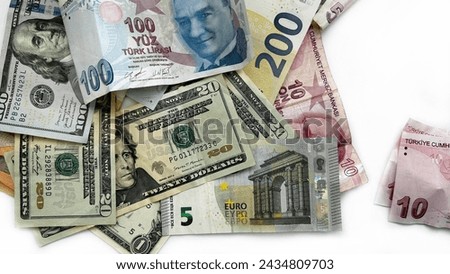 Finances alone against a white background. A mix of Turkish lira bills with US dollars and euros on a brightly lit surface