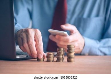 Finances and budgeting, businessman stacking coins on office desk - Shutterstock ID 1085833523
