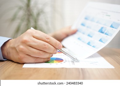 Financial Adviser Is Reviewing Report With Charts And Graphs