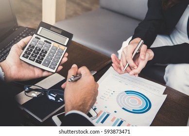 Financial adviser working with client, calculating and analyzing data at the table in cafe - Shutterstock ID 593873471